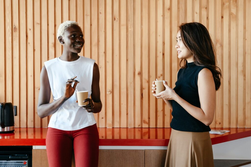 Two women chatting and enjoying coffee during a casual break.